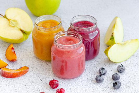 Three jars of colorful homemade baby food,, showcasing the variety and vibrancy of healthy options for storing in reusable silicone pouches.