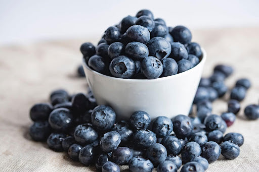 A bowl of fresh blueberries, one of 6 critical superfoods your child needs for a healthy gut.