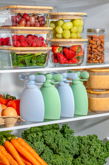 A refrigerator stocked with fresh fruits, vegetables, and reusable food pouches, promoting healthy homemade baby food.