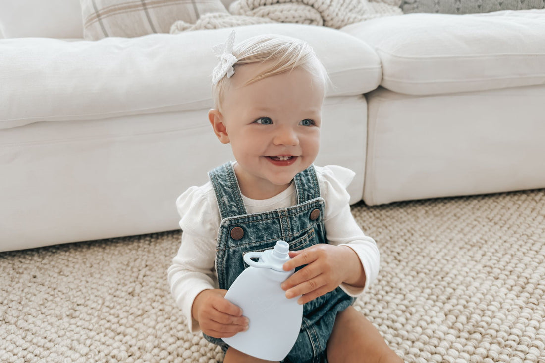 A smiling child enjoys a nourishing homemade snack in her Palmetto Pouch.