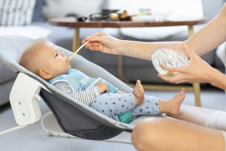 A baby enjoys their first taste of stage 1 baby food